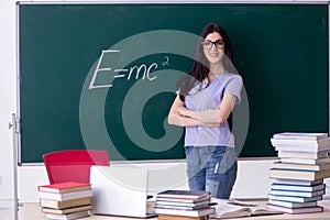 The young female teacher student in front of green board