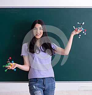 Young female teacher student in front of green board