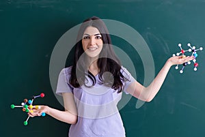 Young female teacher student in front of green board