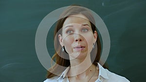 Young female teacher tell interesting to class near the blackboard