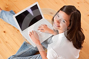 Young female teenager with laptop sitting