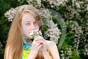 Young female teenager smelling flowers in a garden