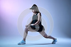 Young female tennis player stretching before the tennis game