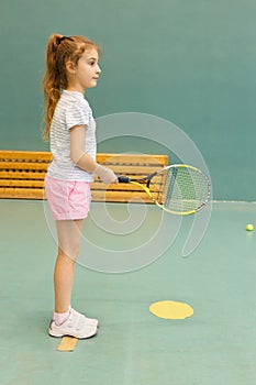 Young female tennis player on tennis court holding