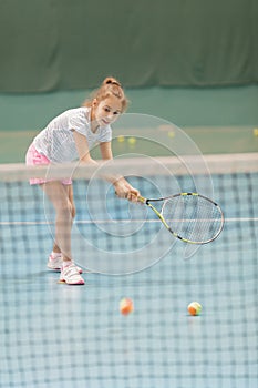 Young female tennis player on tennis court holding