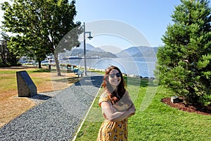 A young female tourist happy and smiling with ocean in the background, visiting the waterfront in Port Alberni, British Columbia photo