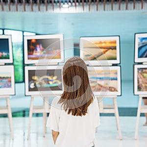 Young female tourist looking gallery exhibition. Art , photography and museum concept