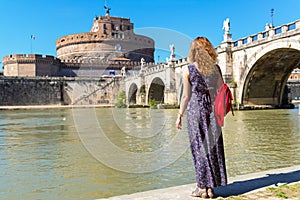 Young female tourist looks at the Castel Sant`Angelo in Rome