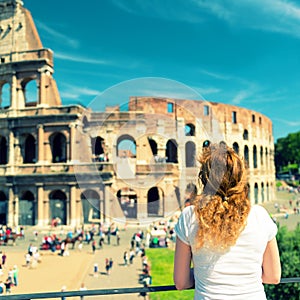 Young female tourist looks at the Colosseum in Rome