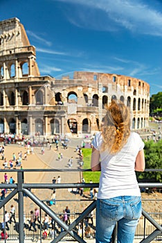 Young female tourist looks at the Colosseum in Rome