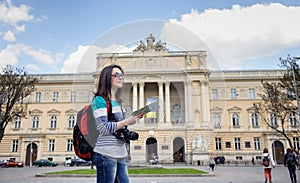 Young female tourist with map and camera