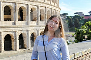 Young female tourist standing near Colosseum in Rome, Italy.