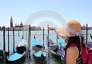 Young female tourist in Venice and gondolas