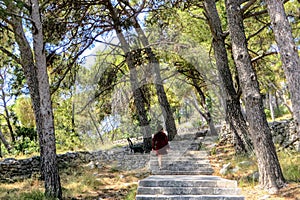 A young female tourist walking through the forests of Marjan Hill, in Split, Croatia.