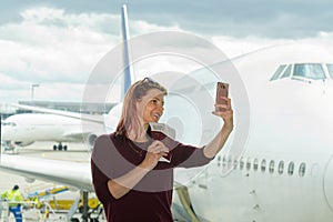 young female traveler, Blogger in airport lounge near windows happy smile taking selfie photo flight