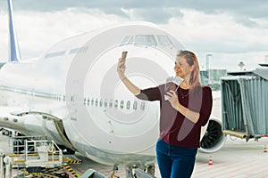 young female traveler, Blogger in airport lounge near windows happy smile taking selfie photo flight