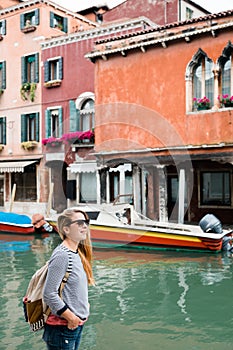 Young female traveler walking by the canal in Murano, Venice - Italy