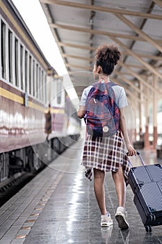 Young female traveler walking standing with a suitcase at train station. woman traveler tourist walking standing smiling