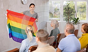 Young female tutor talking to group of seniors about LGBT movements