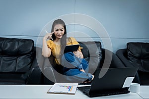 A young female university student uses tablet studying oline sits on couch at home. A teenager woman spends time during covid-19 p photo