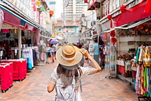Young female walking in Chinatown street market in Singapore