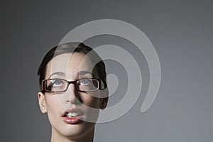 Young Female Wearing spectacles Looking Upwards