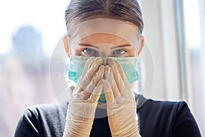 Young female wears surgical mask and protective gloves