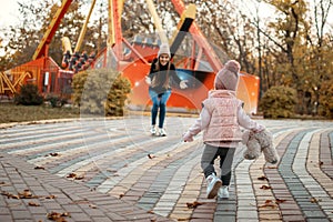 Young female woman babysitter and toddler baby girl walk in autumn park. Happy family mom and toddler outdoors in fall