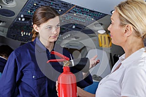 young female worker being shown fire extinguisher photo