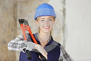 young female worker carrying bolt croppers over shoulder