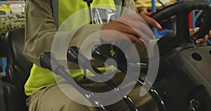 Young female worker driving forklift in a warehouse