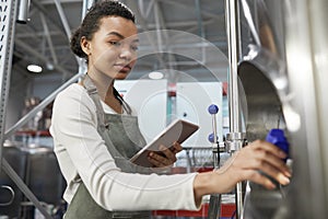 Young Female Worker Opening Valve at Factory