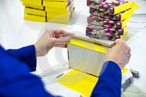 Young female worker packing boxes for shipment in warehouse