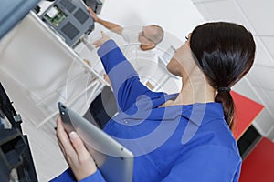 Young female worker using digital tablet in manufacturing industry