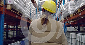 Young female worker walking in a warehouse