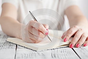 Young female is writing notes and planning her schedule