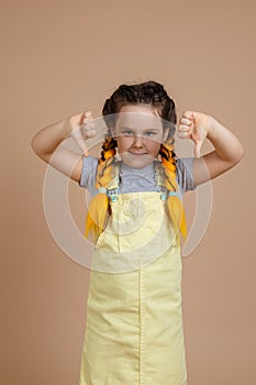 Young female with yellow kanekalon pigtails looking at camera, showing dislike signs with hands smiling wearing yellow
