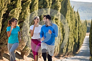 Young females having fun with their personal trainer while jogging