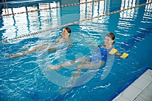 Young females having water aerobics class at indoor swimming pool