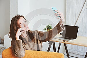 young feminine blogger woman making selfie or online broadcasting on social media alone