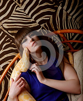 Young fetish woman with bright make up holding Python