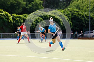 Young field hockey player run on the pitch in attack