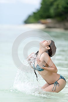 Young Filipina woman splashing