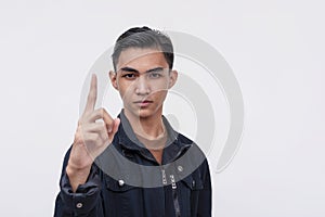 A young Filipino man gives a stern warning. A no-nonsense guy confronting and reprimanding someone with a finger gesture. Isolated photo