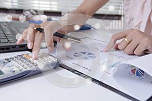 Young finance market analyst working at office on laptop while sitting at white table.Businessman analyze document