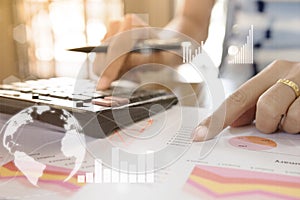 Young finance market analyst working at office at white table.Businessman analyze document and the calculator in hands photo