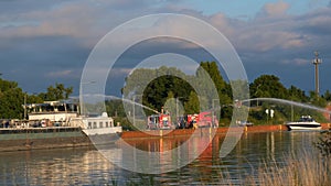 Young firefighters practice hosing down water on the banks of a water canal in Germany