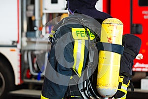 Young fireman in uniform in front of firetruck