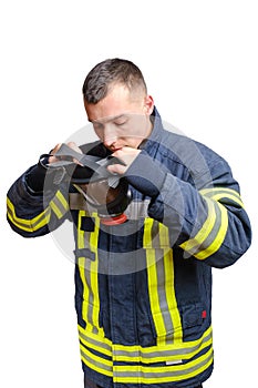 Young fireman in uniform puts full facepiece respirator over his head