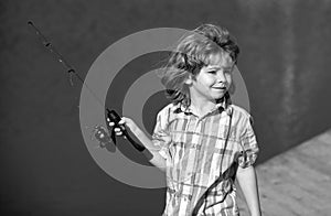 Young fisher. Child fishing at river bank, summer outdoor leisure activity. Little kid at river bank with rod. Angling.